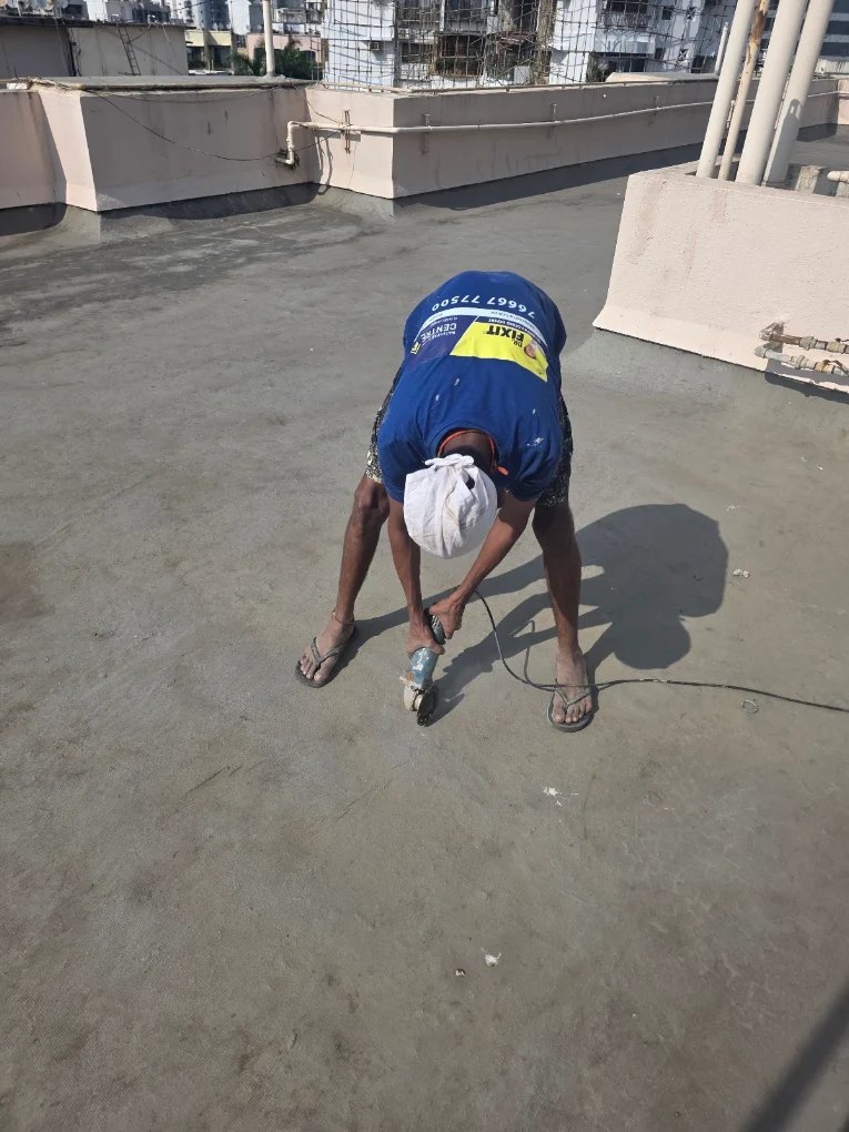 Worker cutting along a terrace crack line before sealing